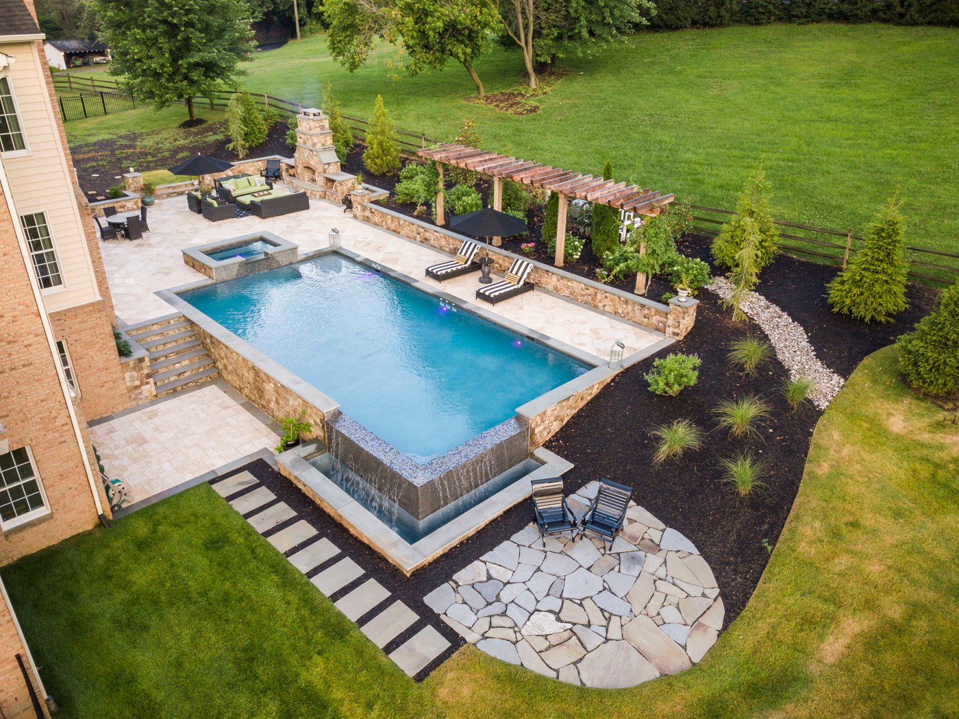 aerial view of pool and patio with outdoor fireplace